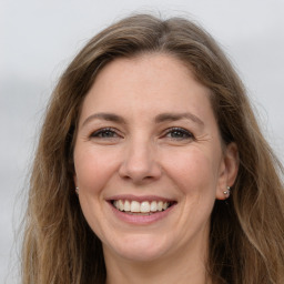 Joyful white adult female with long  brown hair and grey eyes