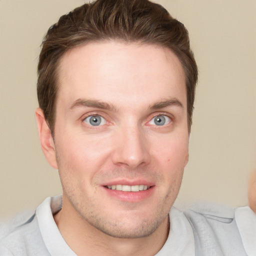 Joyful white young-adult male with short  brown hair and grey eyes