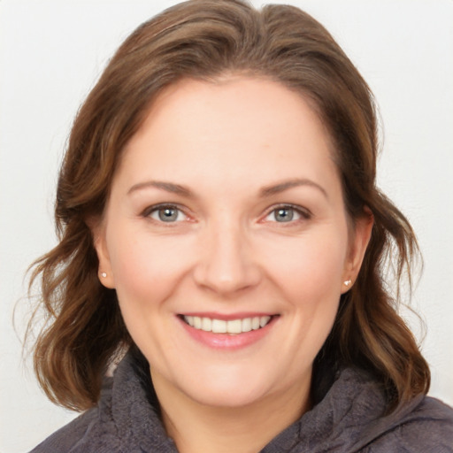 Joyful white young-adult female with medium  brown hair and grey eyes