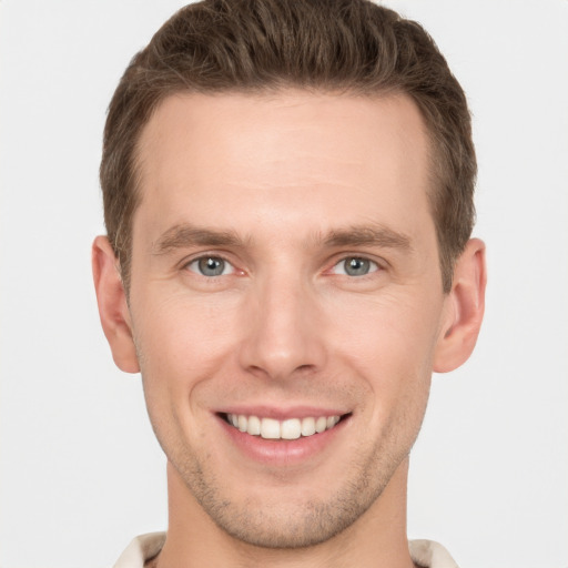 Joyful white young-adult male with short  brown hair and grey eyes