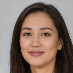 Joyful latino young-adult female with long  brown hair and brown eyes