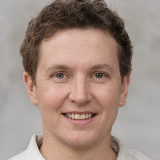 Joyful white adult male with short  brown hair and grey eyes