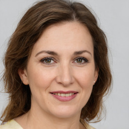 Joyful white adult female with medium  brown hair and green eyes