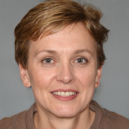 Joyful white adult female with medium  brown hair and blue eyes