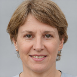 Joyful white adult female with medium  brown hair and grey eyes