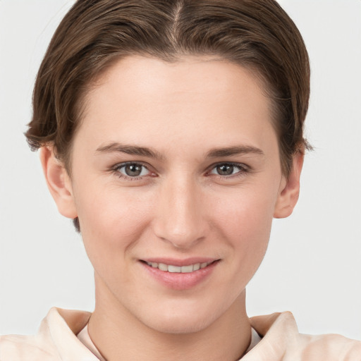 Joyful white young-adult female with short  brown hair and grey eyes