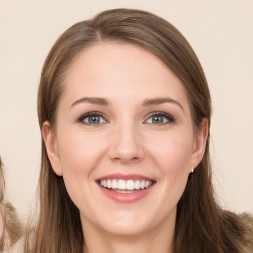 Joyful white young-adult female with long  brown hair and blue eyes