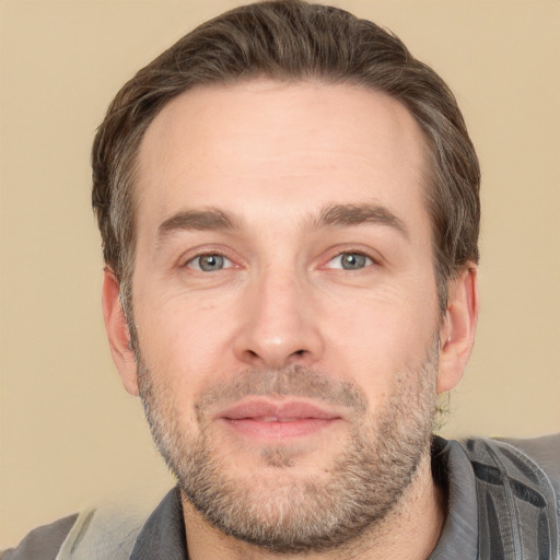 Joyful white adult male with short  brown hair and brown eyes