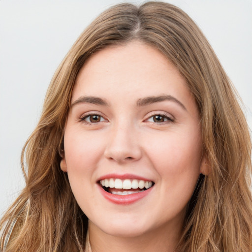 Joyful white young-adult female with long  brown hair and green eyes