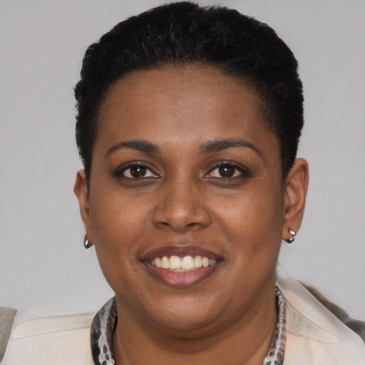 Joyful black young-adult female with short  black hair and brown eyes