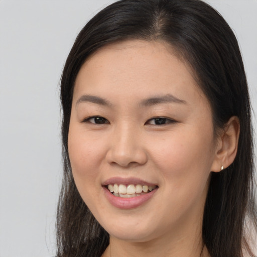 Joyful asian young-adult female with long  brown hair and brown eyes