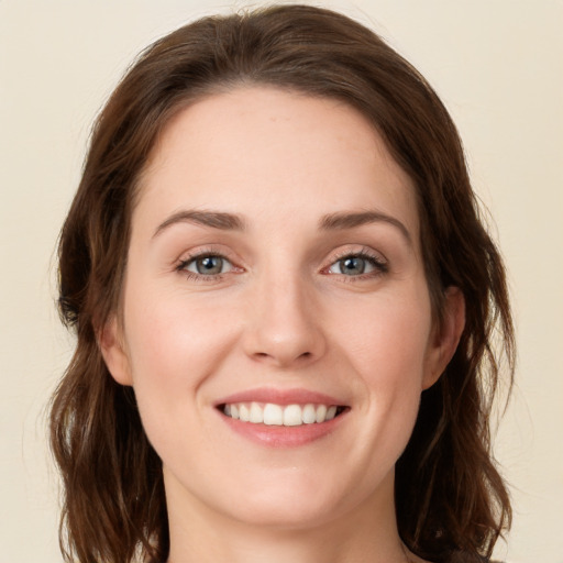 Joyful white young-adult female with long  brown hair and green eyes