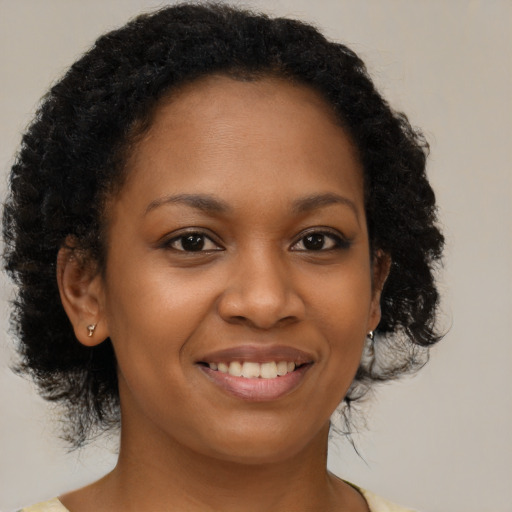 Joyful black young-adult female with medium  brown hair and brown eyes