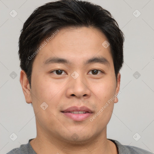 Joyful asian young-adult male with short  brown hair and brown eyes