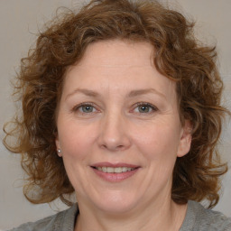 Joyful white adult female with medium  brown hair and blue eyes