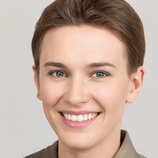 Joyful white young-adult female with short  brown hair and grey eyes