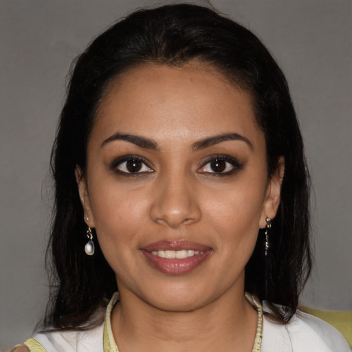 Joyful latino young-adult female with medium  brown hair and brown eyes