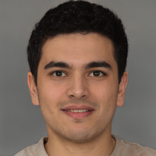 Joyful latino young-adult male with short  brown hair and brown eyes
