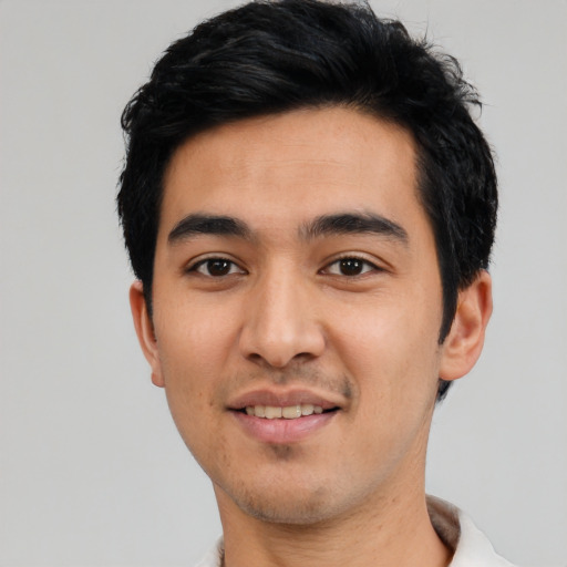 Joyful latino young-adult male with short  black hair and brown eyes