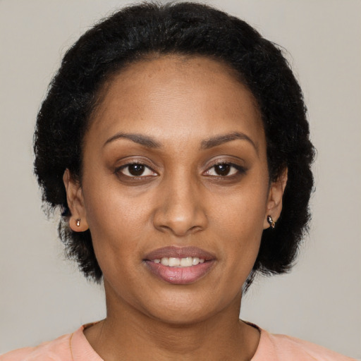 Joyful black young-adult female with medium  brown hair and brown eyes