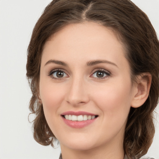 Joyful white young-adult female with medium  brown hair and green eyes