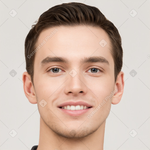 Joyful white young-adult male with short  brown hair and grey eyes