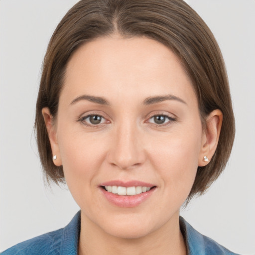 Joyful white young-adult female with medium  brown hair and grey eyes