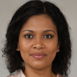 Joyful black adult female with medium  brown hair and brown eyes