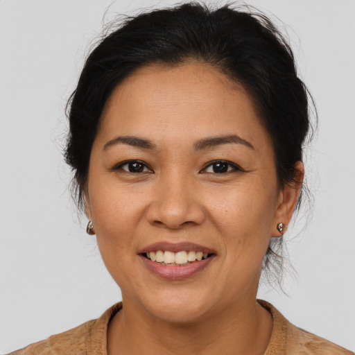 Joyful latino adult female with medium  brown hair and brown eyes