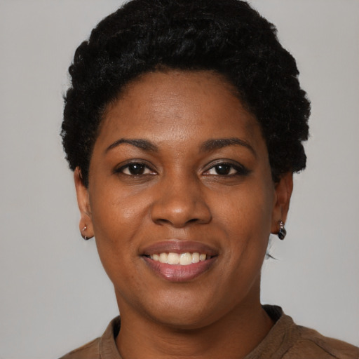 Joyful black young-adult female with short  black hair and brown eyes