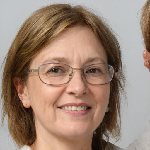 Joyful white middle-aged female with medium  brown hair and blue eyes