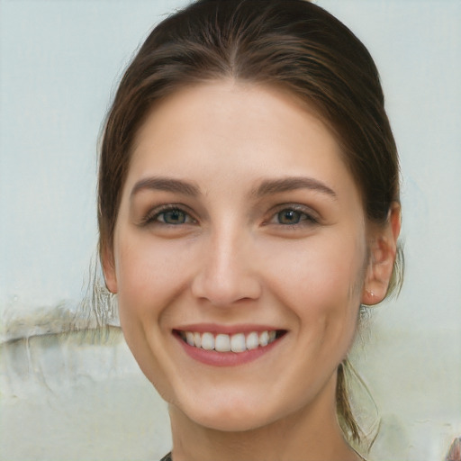 Joyful white young-adult female with long  brown hair and green eyes