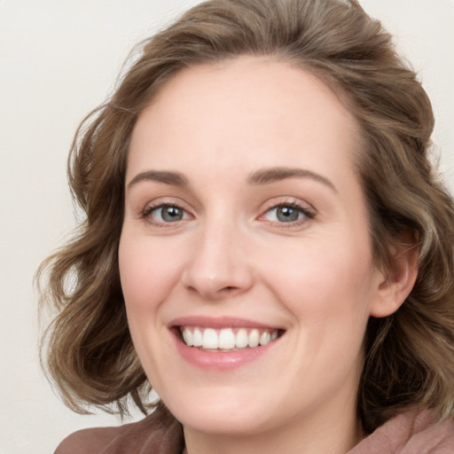 Joyful white young-adult female with medium  brown hair and blue eyes