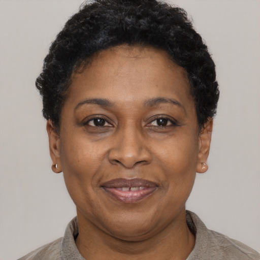 Joyful black adult female with short  black hair and brown eyes