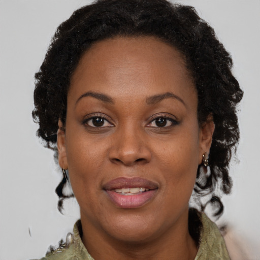 Joyful black adult female with medium  brown hair and brown eyes