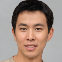 Joyful asian young-adult male with short  brown hair and brown eyes