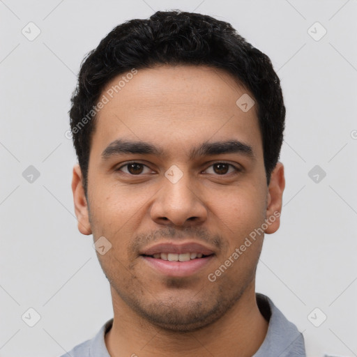 Joyful latino young-adult male with short  black hair and brown eyes