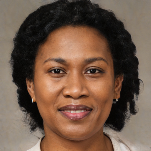 Joyful black adult female with medium  black hair and brown eyes