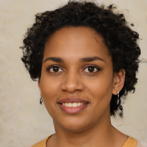 Joyful black young-adult female with short  brown hair and brown eyes