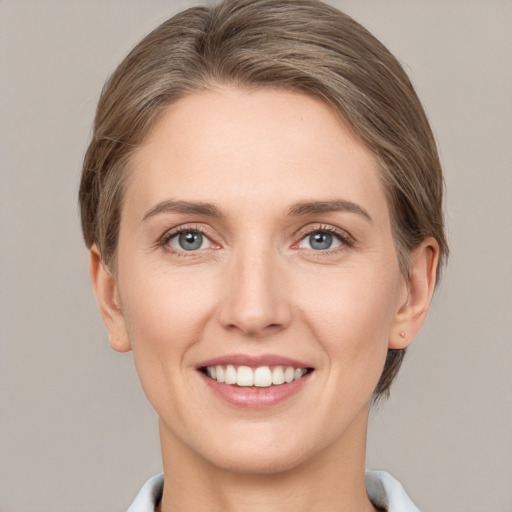 Joyful white young-adult female with short  brown hair and grey eyes