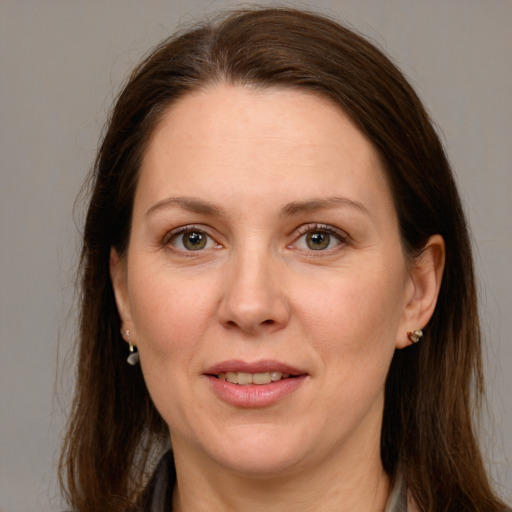 Joyful white adult female with long  brown hair and grey eyes