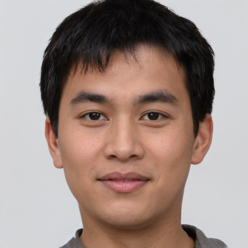 Joyful asian young-adult male with short  brown hair and brown eyes