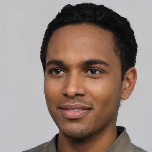 Joyful black young-adult male with short  black hair and brown eyes