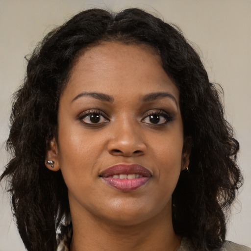 Joyful black young-adult female with long  brown hair and brown eyes