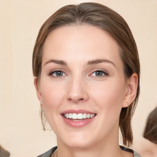 Joyful white young-adult female with medium  brown hair and grey eyes