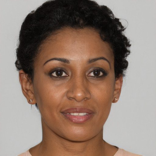 Joyful black young-adult female with short  black hair and brown eyes