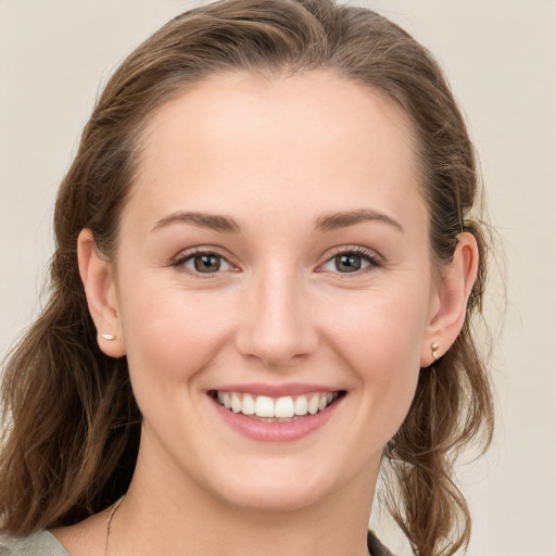 Joyful white young-adult female with medium  brown hair and grey eyes