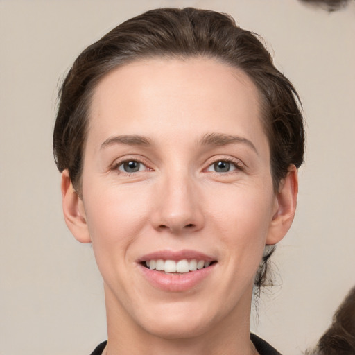 Joyful white young-adult female with medium  brown hair and grey eyes