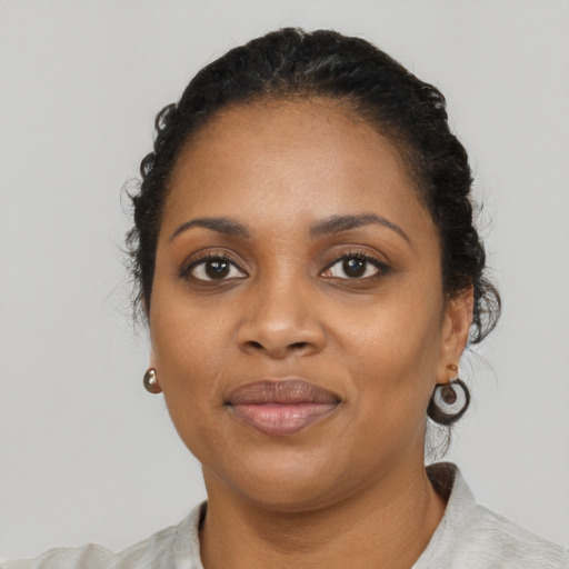 Joyful black young-adult female with short  black hair and brown eyes