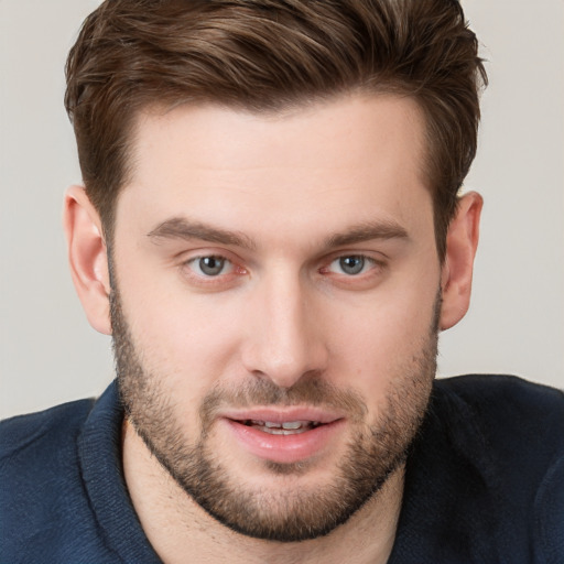 Joyful white young-adult male with short  brown hair and grey eyes